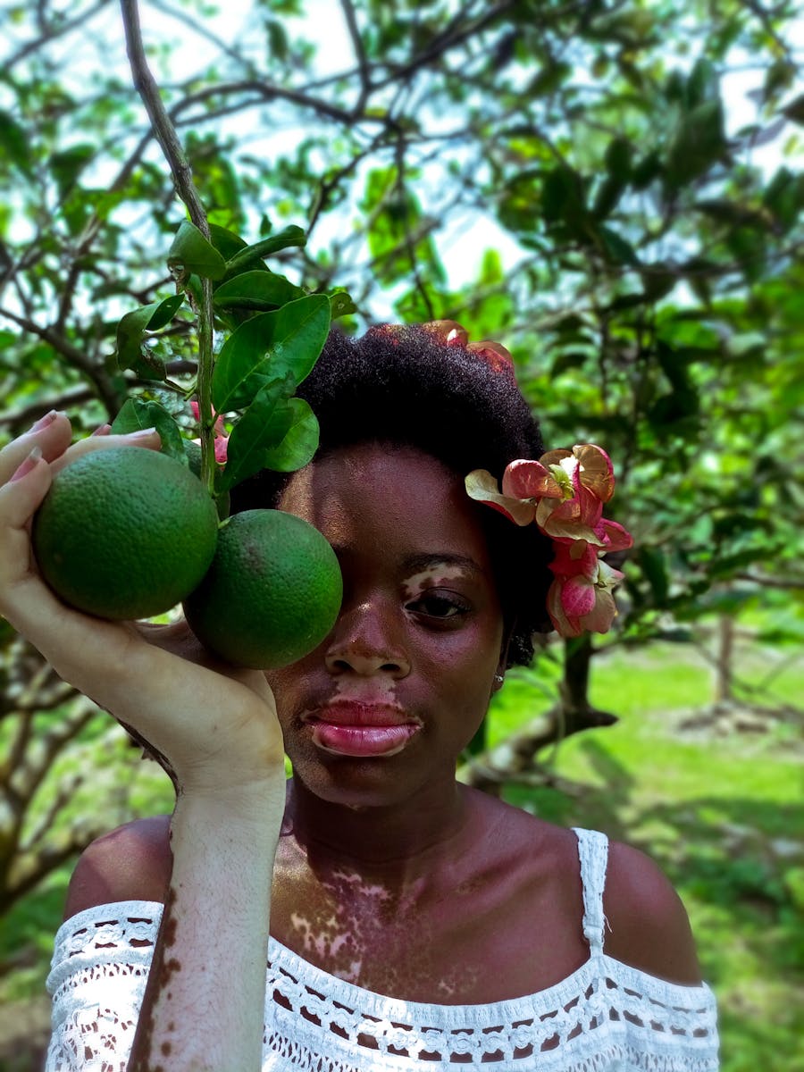 Photo of a Woman Holding Green Fruits